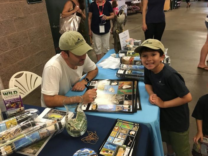 Fiorentino signing a poster of his artwork for an eager fan